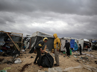 Palestinian displaced persons inspect their tents, which are damaged by wind and rain after heavy rainfall in Deir al-Balah, central Gaza St...