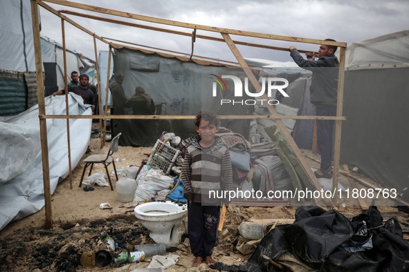 Palestinian displaced persons inspect their tents, which are damaged by wind and rain after heavy rainfall in Deir al-Balah, central Gaza St...