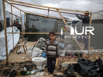 Palestinian displaced persons inspect their tents, which are damaged by wind and rain after heavy rainfall in Deir al-Balah, central Gaza St...