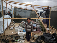 Palestinian displaced persons inspect their tents, which are damaged by wind and rain after heavy rainfall in Deir al-Balah, central Gaza St...