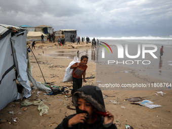 Palestinian displaced persons inspect their tents, which are damaged by wind and rain after heavy rainfall in Deir al-Balah, central Gaza St...