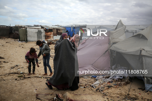 Palestinian displaced persons inspect their tents, which are damaged by wind and rain after heavy rainfall in Deir al-Balah, central Gaza St...