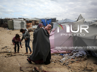 Palestinian displaced persons inspect their tents, which are damaged by wind and rain after heavy rainfall in Deir al-Balah, central Gaza St...