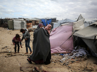 Palestinian displaced persons inspect their tents, which are damaged by wind and rain after heavy rainfall in Deir al-Balah, central Gaza St...