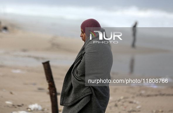 A displaced Palestinian woman stands outside her tent, which is damaged by wind and rain following heavy rainfall in Deir al-Balah, central...