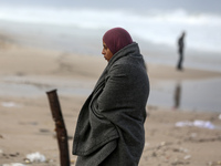 A displaced Palestinian woman stands outside her tent, which is damaged by wind and rain following heavy rainfall in Deir al-Balah, central...