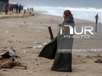 A displaced Palestinian woman stands outside her tent, which is damaged by wind and rain following heavy rainfall in Deir al-Balah, central...