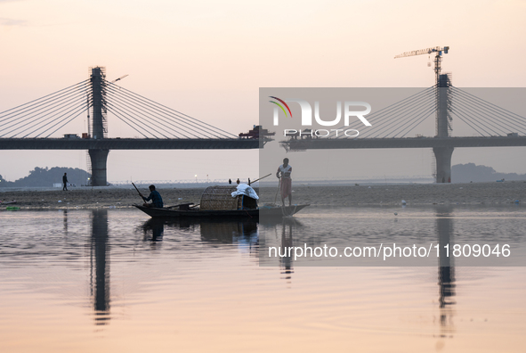 Fishermen lay their fishing net in the Brahmaputra River during sunset in Guwahati, India, on November 25, 2024. 