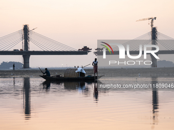 Fishermen lay their fishing net in the Brahmaputra River during sunset in Guwahati, India, on November 25, 2024. (