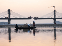 Fishermen lay their fishing net in the Brahmaputra River during sunset in Guwahati, India, on November 25, 2024. (