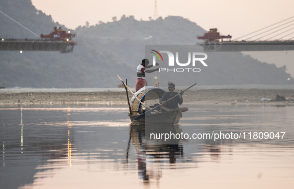 Fishermen lay their fishing net in the Brahmaputra River during sunset in Guwahati, India, on November 25, 2024. 