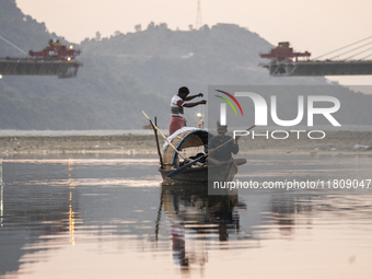 Fishermen lay their fishing net in the Brahmaputra River during sunset in Guwahati, India, on November 25, 2024. (