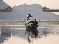 Fishermen lay their fishing net in the Brahmaputra River during sunset in Guwahati, India, on November 25, 2024. (