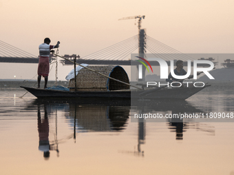 Fishermen lay their fishing net in the Brahmaputra River during sunset in Guwahati, India, on November 25, 2024. (