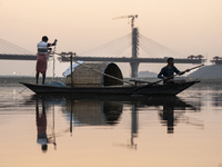 Fishermen lay their fishing net in the Brahmaputra River during sunset in Guwahati, India, on November 25, 2024. (