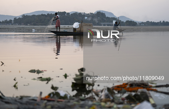 Fishermen lay their fishing net in the Brahmaputra River during sunset in Guwahati, India, on November 25, 2024. 