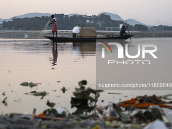 Fishermen lay their fishing net in the Brahmaputra River during sunset in Guwahati, India, on November 25, 2024. (