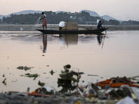 Fishermen lay their fishing net in the Brahmaputra River during sunset in Guwahati, India, on November 25, 2024. (