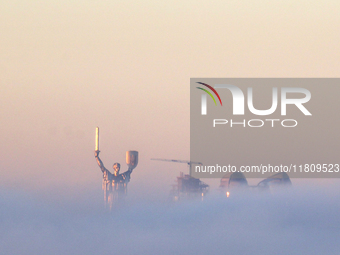 The Motherland monument is seen through the dense fog in Kyiv, Ukraine, on November 25, 2024. (