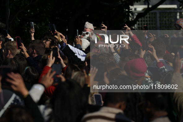 A baby is held above a crowd as President Joe Biden greets people at the 77th anniversary of the National Thanksgiving Turkey presentation o...