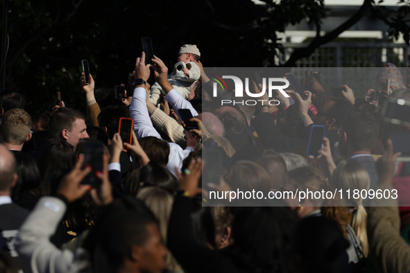 A baby is held above a crowd as President Joe Biden greets people at the 77th anniversary of the National Thanksgiving Turkey presentation o...