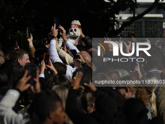 A baby is held above a crowd as President Joe Biden greets people at the 77th anniversary of the National Thanksgiving Turkey presentation o...