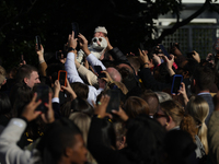 A baby is held above a crowd as President Joe Biden greets people at the 77th anniversary of the National Thanksgiving Turkey presentation o...