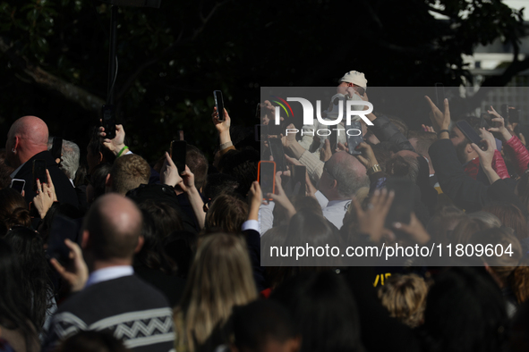 A baby is held above a crowd as President Joe Biden greets people at the 77th anniversary of the National Thanksgiving Turkey presentation o...