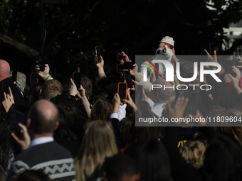 A baby is held above a crowd as President Joe Biden greets people at the 77th anniversary of the National Thanksgiving Turkey presentation o...