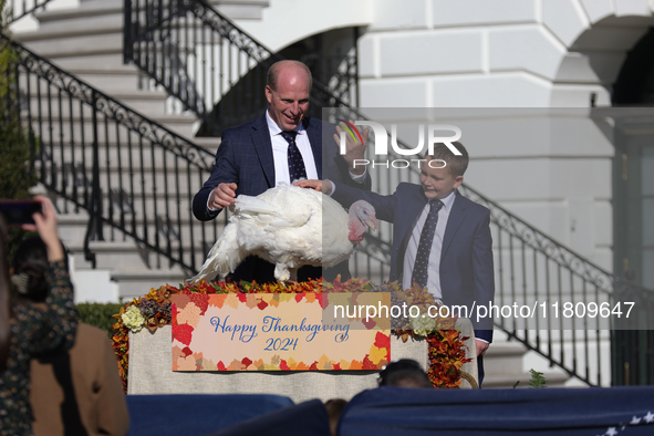 National Turkey Foundation chairman John Zimmerman and his son Grant present a turkey the 77th anniversary of the National Thanksgiving Turk...