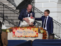 National Turkey Foundation chairman John Zimmerman and his son Grant present a turkey the 77th anniversary of the National Thanksgiving Turk...