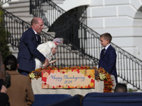 National Turkey Foundation chairman John Zimmerman and his son Grant present a turkey the 77th anniversary of the National Thanksgiving Turk...