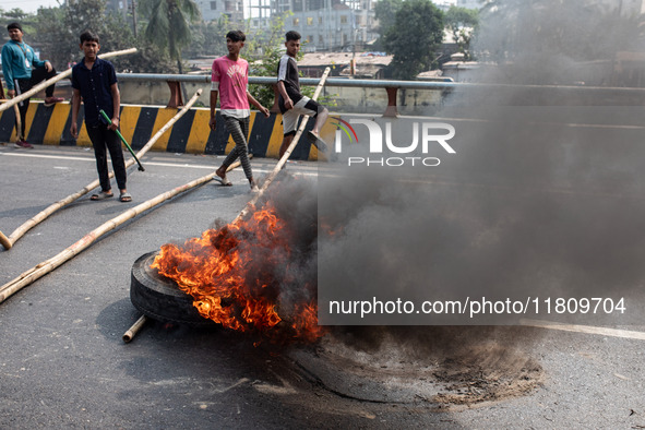 Students of Dr. Mahbubur Rahman Molla College set fire to a tire before they engage in a clash with students from Kabi Nazrul College and Su...