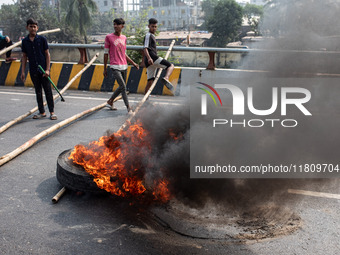 Students of Dr. Mahbubur Rahman Molla College set fire to a tire before they engage in a clash with students from Kabi Nazrul College and Su...