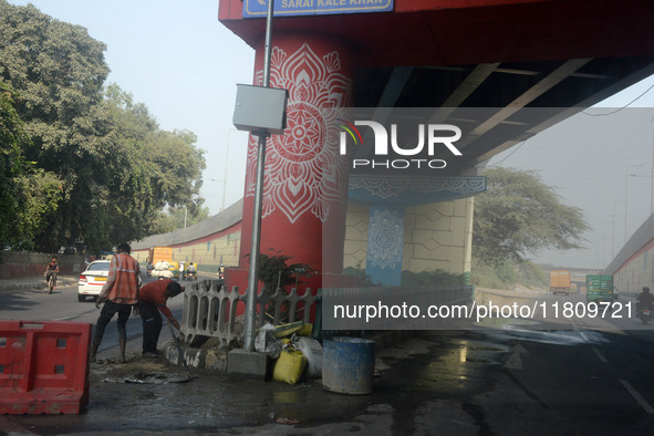 People walk on the foot over bridge during smoggy conditions in New Delhi, India, on November 24, 2024. 