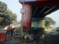 People walk on the foot over bridge during smoggy conditions in New Delhi, India, on November 24, 2024. (