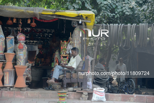 An Indian man sits at his roadside shop in New Delhi, India, on November 24, 2024. 