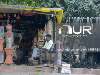 An Indian man sits at his roadside shop in New Delhi, India, on November 24, 2024. (