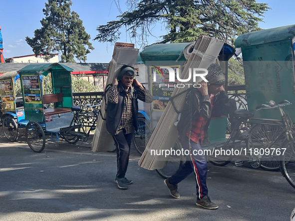 Laborers carry planks of wood along the Mall Road in Mussoorie, Uttarakhand, India, on April 18, 2024. 