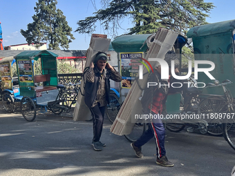 Laborers carry planks of wood along the Mall Road in Mussoorie, Uttarakhand, India, on April 18, 2024. (