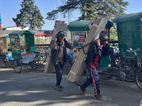 Laborers carry planks of wood along the Mall Road in Mussoorie, Uttarakhand, India, on April 18, 2024. (