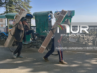 Laborers carry planks of wood along the Mall Road in Mussoorie, Uttarakhand, India, on April 18, 2024. (