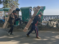 Laborers carry planks of wood along the Mall Road in Mussoorie, Uttarakhand, India, on April 18, 2024. (