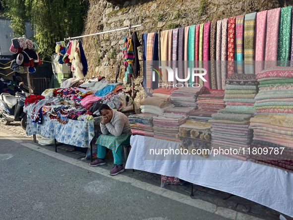 A woman sells clothing along the Mall Road in Mussoorie, Uttarakhand, India, on April 18, 2024. 