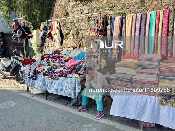 A woman sells clothing along the Mall Road in Mussoorie, Uttarakhand, India, on April 18, 2024. 