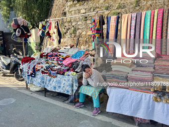 A woman sells clothing along the Mall Road in Mussoorie, Uttarakhand, India, on April 18, 2024. (