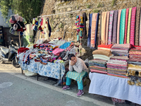 A woman sells clothing along the Mall Road in Mussoorie, Uttarakhand, India, on April 18, 2024. (