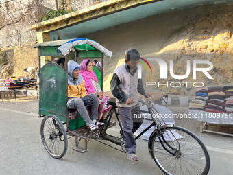 A rickshaw driver ferries people along the Mall Road in Mussoorie, Uttarakhand, India, on April 18, 2024. (