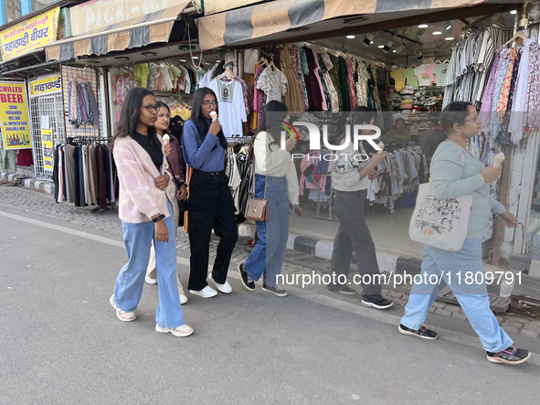 Indian tourists eat ice cream while walking along the Mall Road in Mussoorie, Uttarakhand, India, on April 18, 2024. 