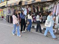 Indian tourists eat ice cream while walking along the Mall Road in Mussoorie, Uttarakhand, India, on April 18, 2024. (